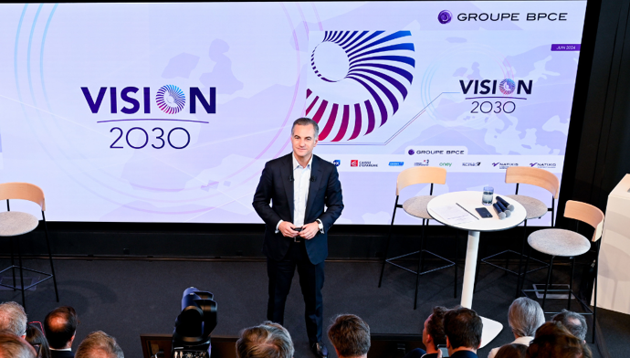 visuel de Nicolas Namias face un public avec le visuel de Vision 2023 en arrière plan