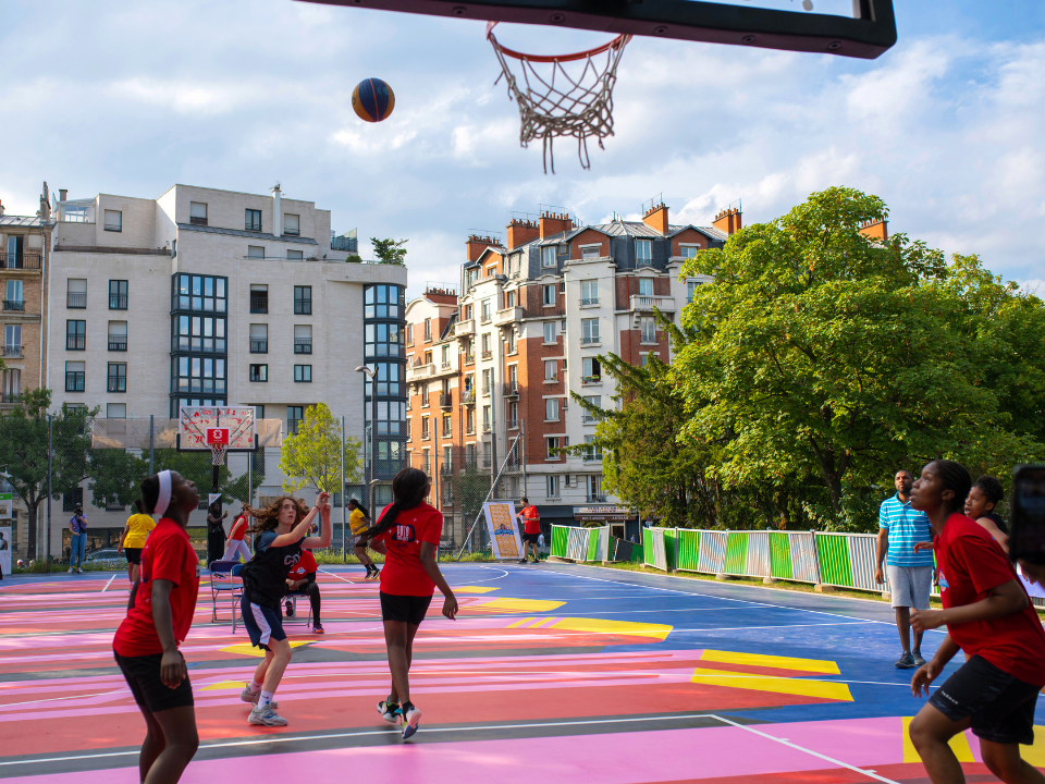 un terrain de basket en ville avec des jeunes qui jouent