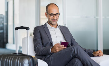 Homme sur son téléphone et avec une valise