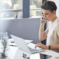 jeune femme au téléphone et sur son ordinateur