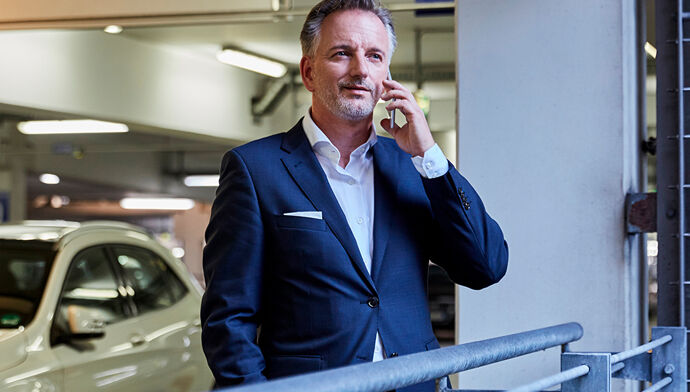 professionnel au téléphone sur un parking