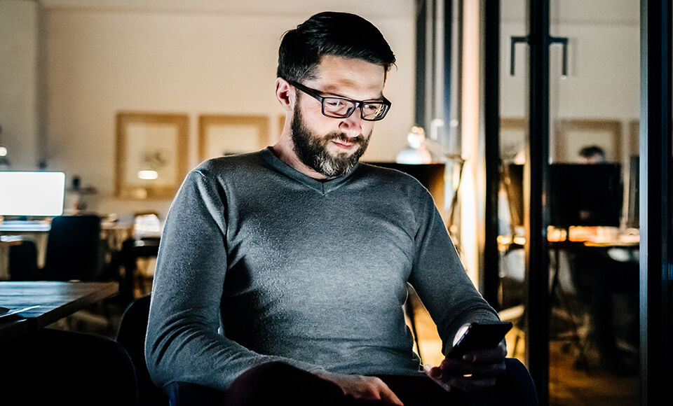 homme consultant son téléphone au bureau