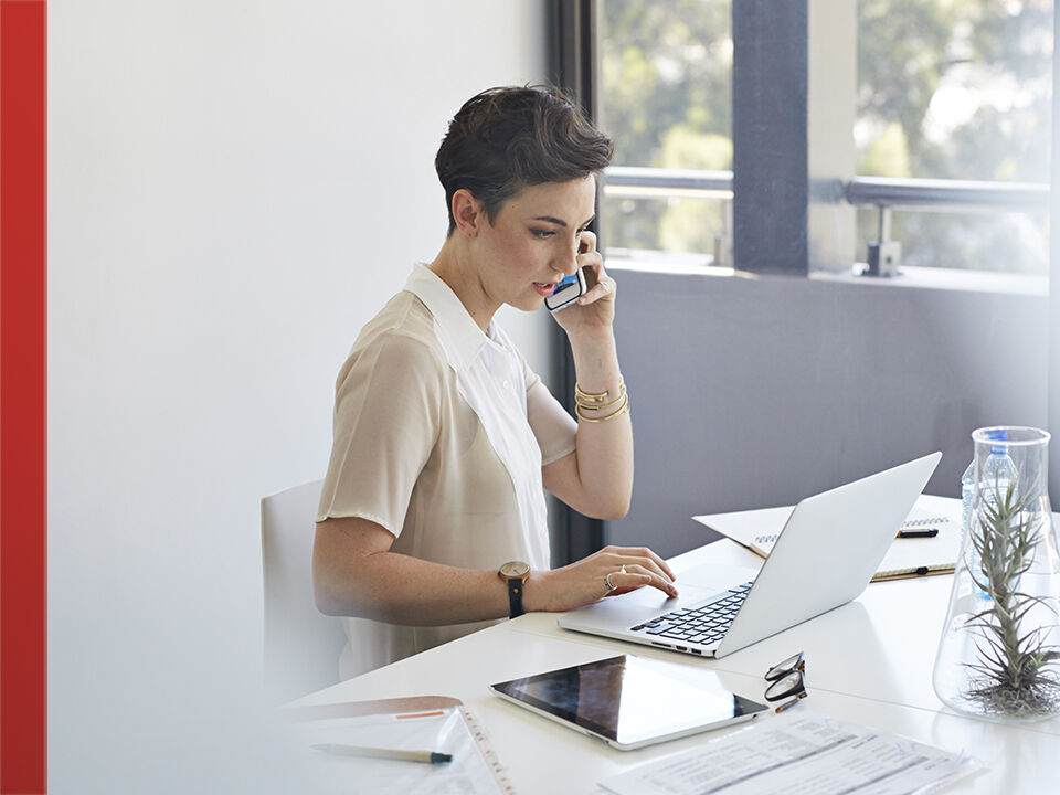 jeune femme au téléphone et sur son ordinateur
