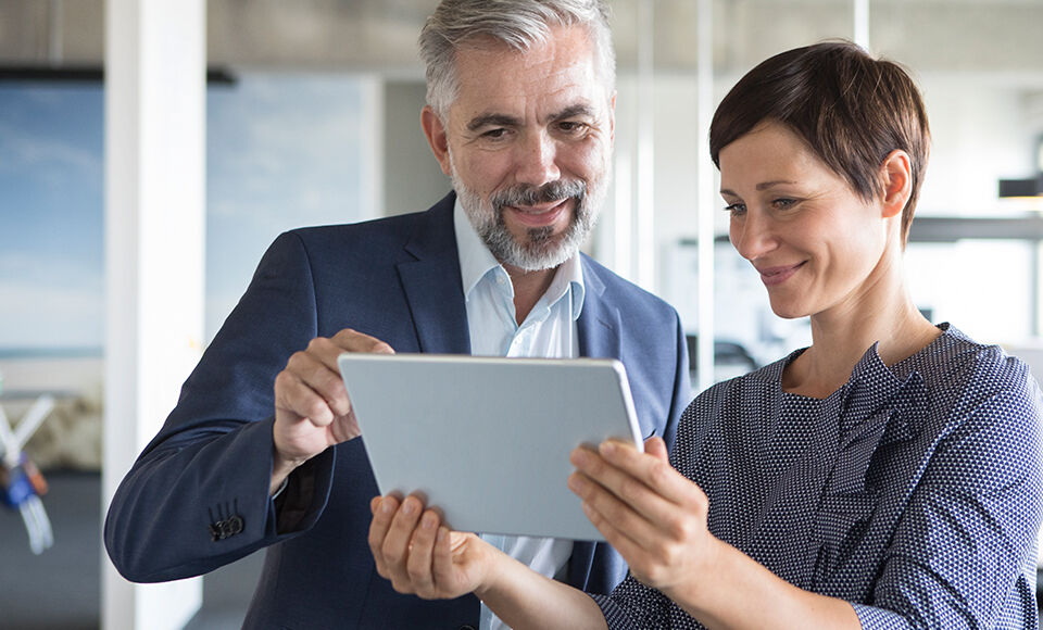 deux personnes consultant une tablette
