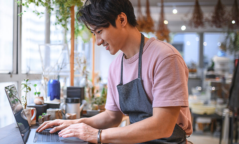 Homme souriant sur son ordinateur
