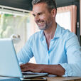 homme souriant sur son ordinateur