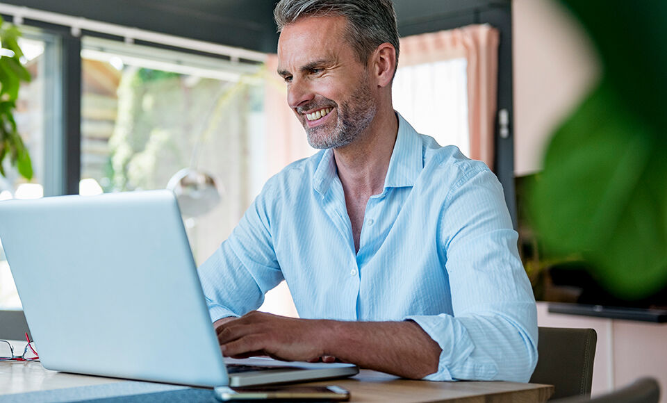 homme souriant sur son ordinateur