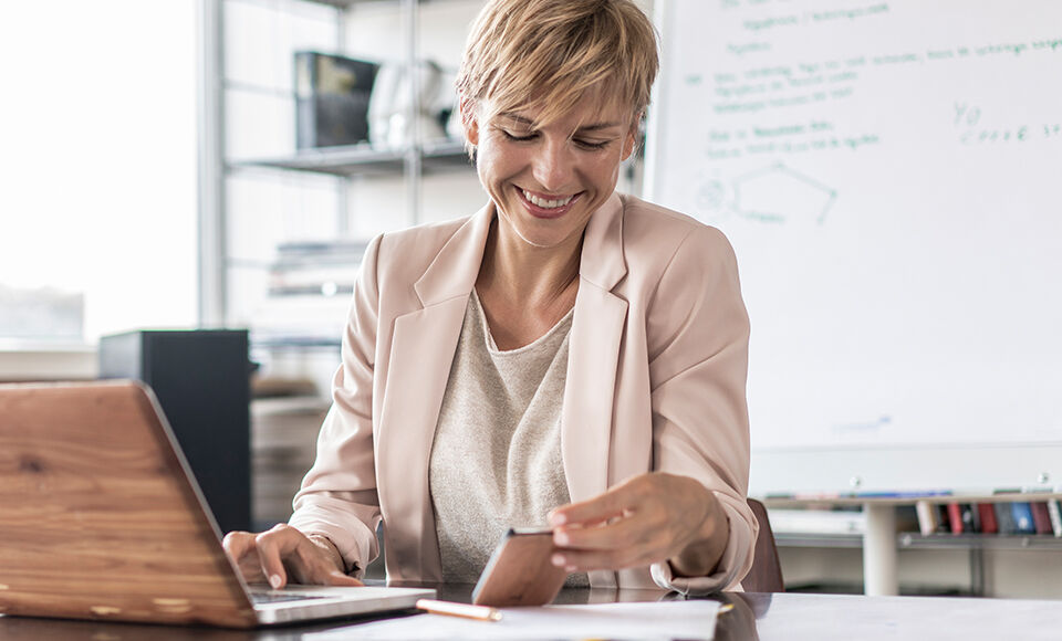 femme souriant avec t&eacute;l&eacute;phone