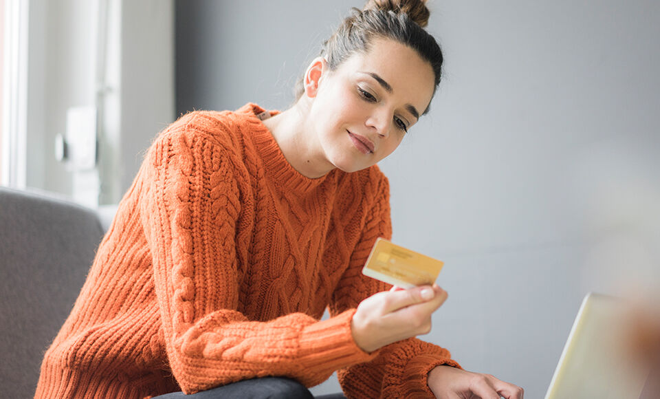 Une femme regarde sa carte bancaire.