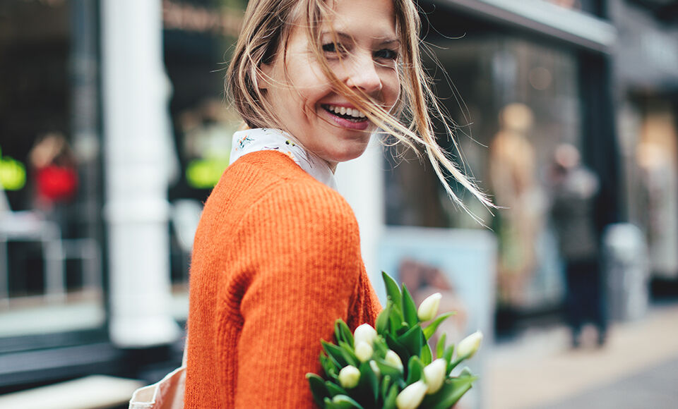 femme souriante avec bouquet de fleures