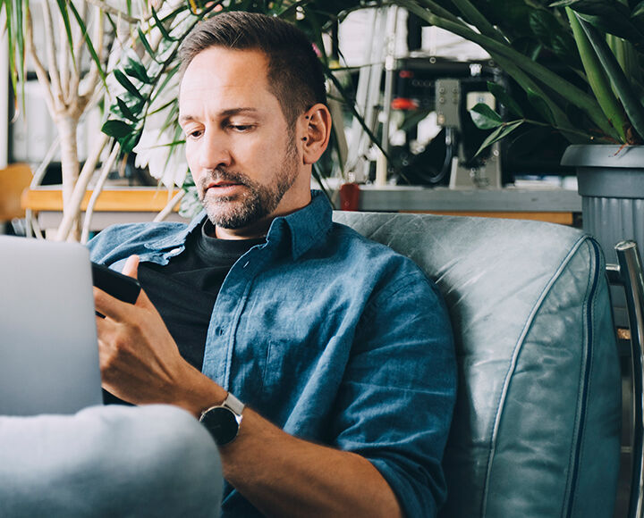 homme étant sur son smartphone et son pc