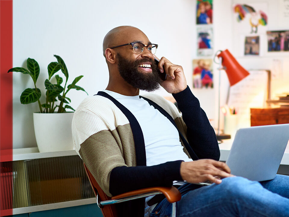 homme souriant au t&eacute;l&eacute;phone