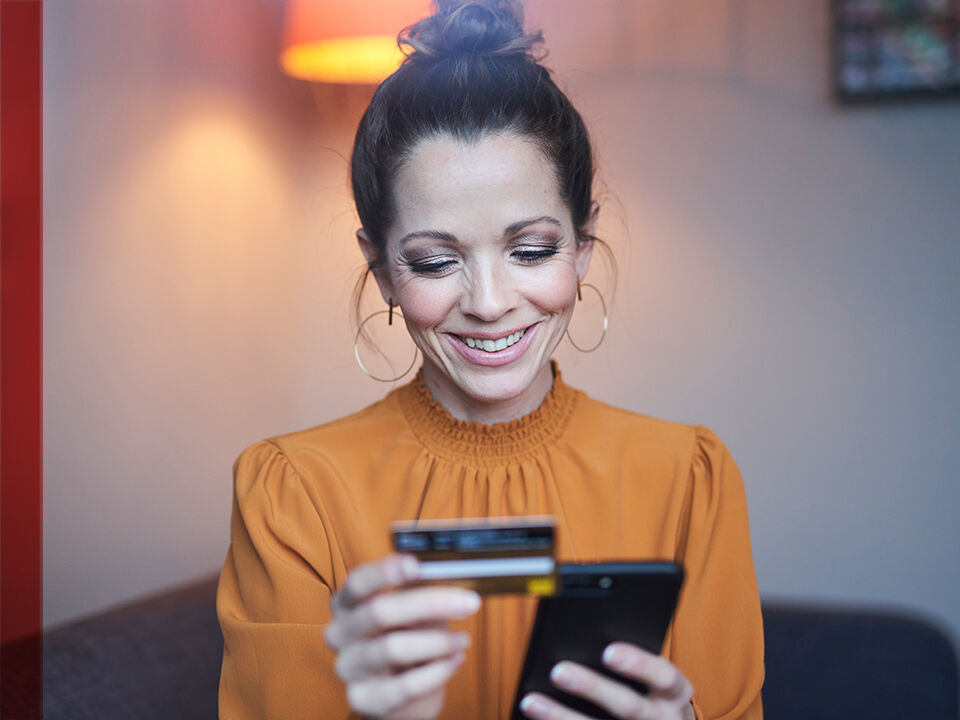 femme sur son smartphone avec carte bancaire