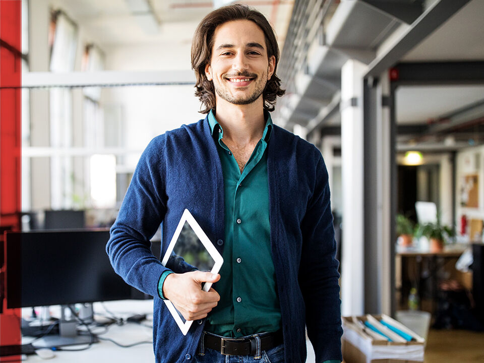 Jeune homme tenant sa tablette en entreprise