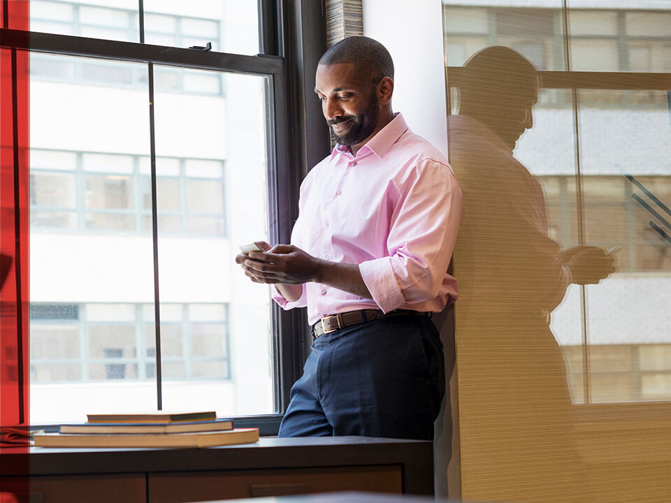 homme consultant son téléphone au bureau