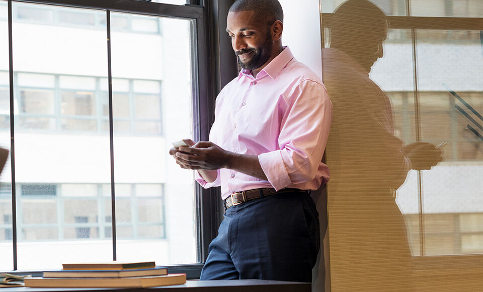 homme consultant son téléphone au bureau