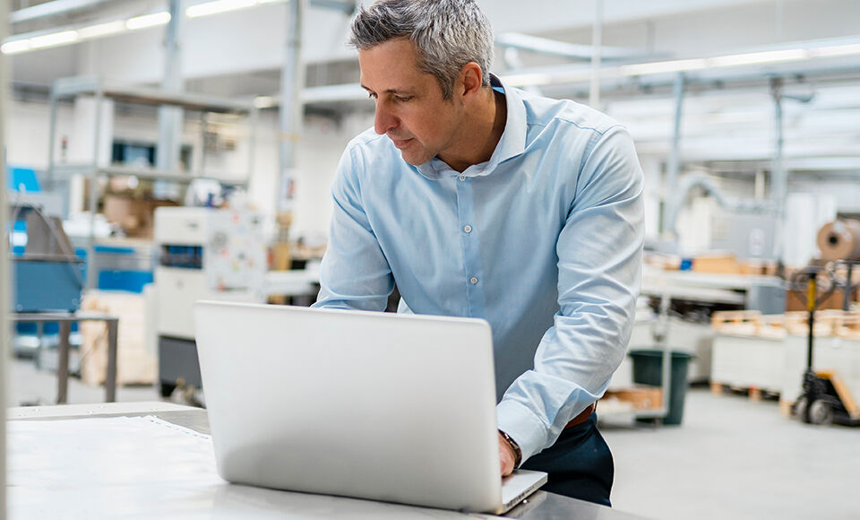 homme travaillant debout sur son ordinateur