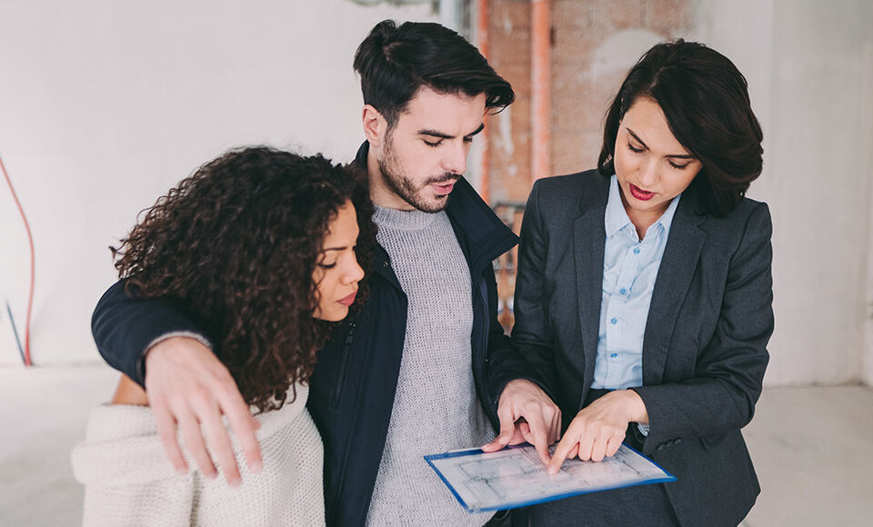 Trois personnes regardent un document.