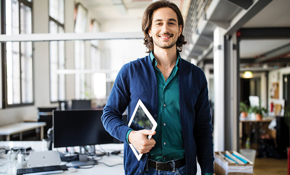 Homme souriant portant une tablette
