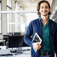 Homme souriant portant une tablette