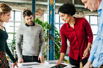 Groupe de personnes travaillant ensemble sur un sujet en entreprise.