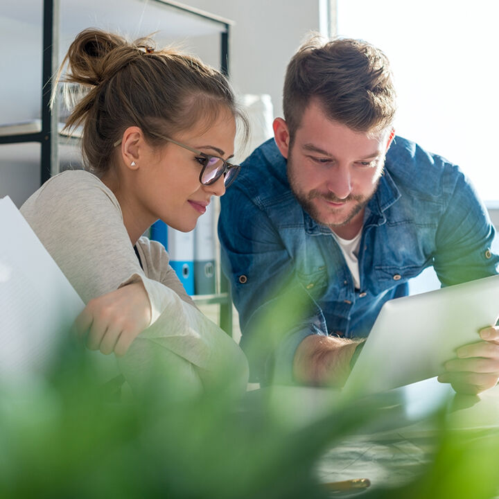 un homme et une femme en r&eacute;union devant une tablette