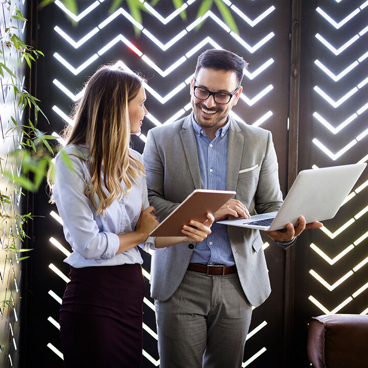 un homme et une femme en r&eacute;union avec tablette et ordinateur portable