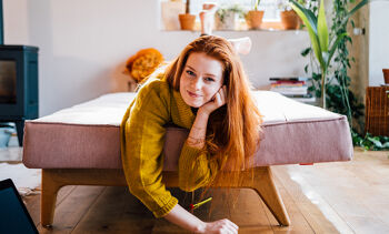 Jeune fille rousse allongée sur un lit