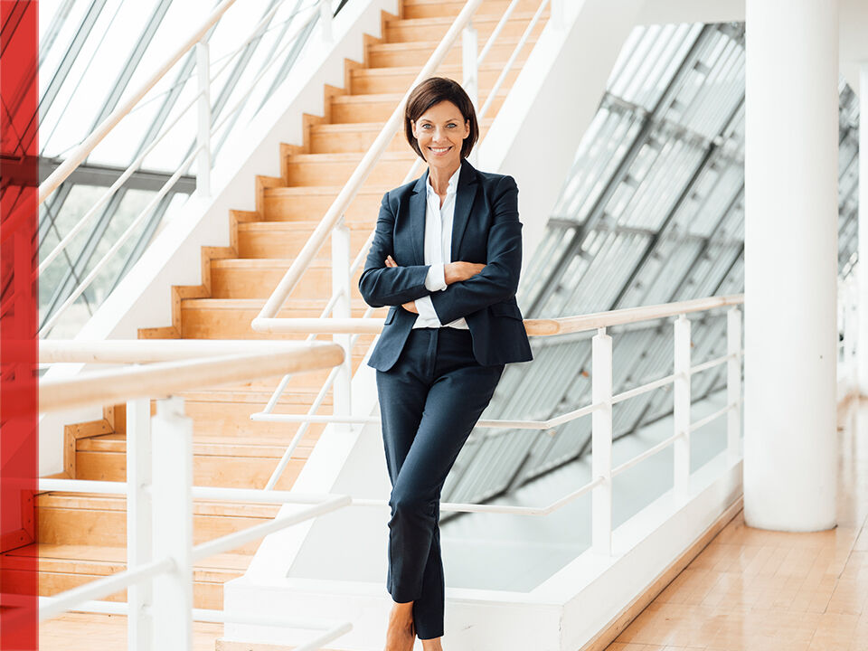 Femme en costume accoudée sur un escalier
