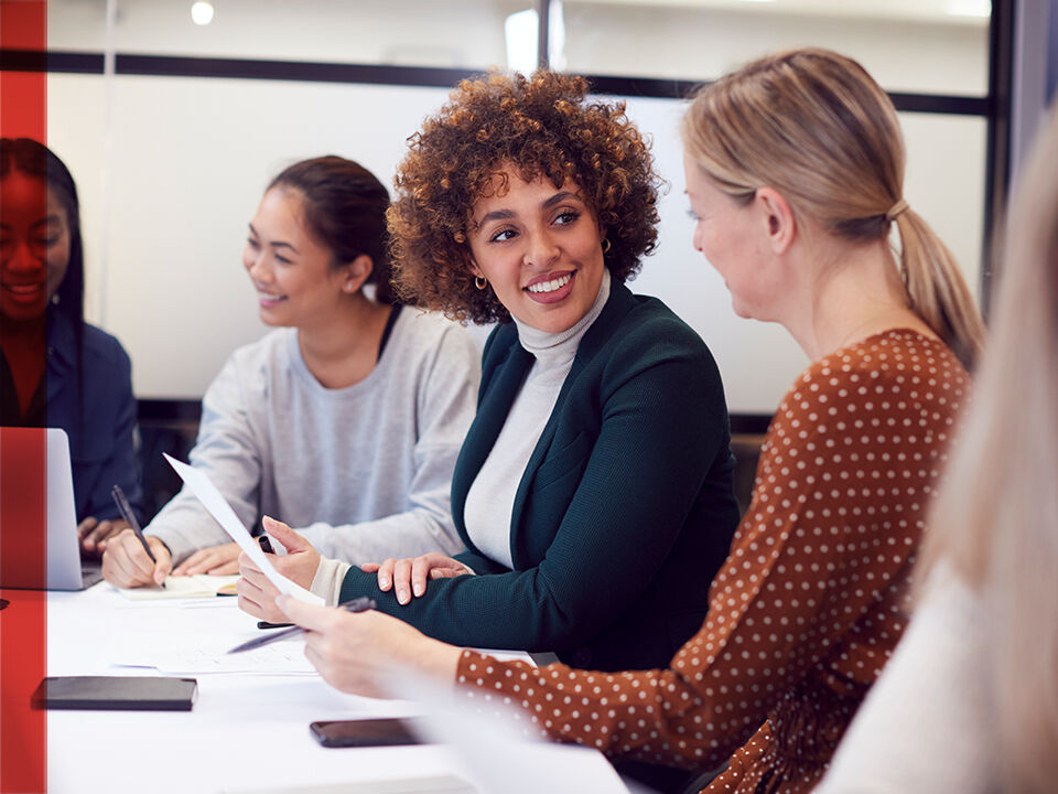 3 femmes discutent dans une salle de réunion
