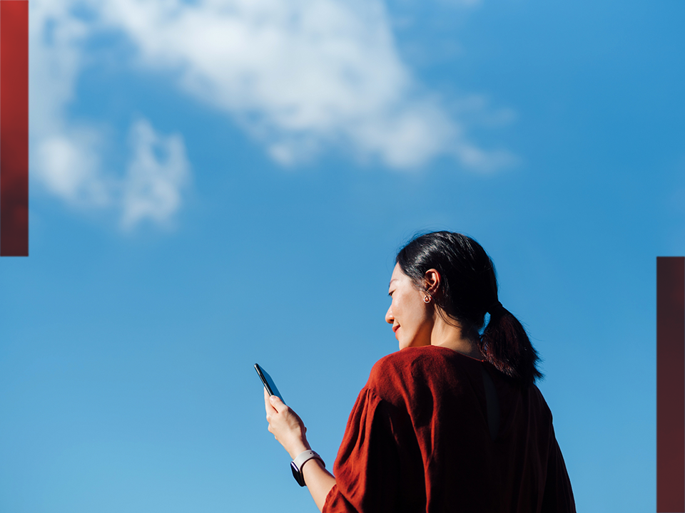 Jeune femme avec un haut rouge et un téléphone à la main