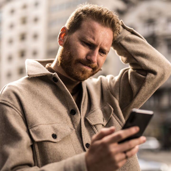 Homme inquiet sur son t&eacute;l&eacute;phone