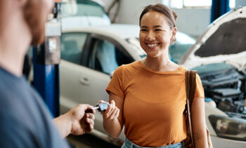 Jeune femme qui récupère les clés de sa nouvelle voiture
