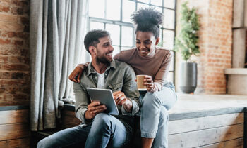 Jeune couple qui regarde leur tablette