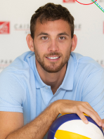 Un homme tient un ballon de volley.