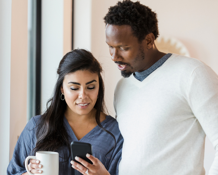 Un homme et une femme regardent un téléphone.