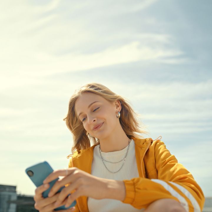 femme en jaune avec son telephone