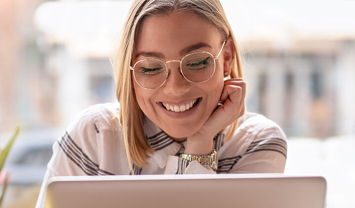 Femme souriant face à son ordinateur portable